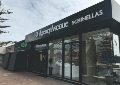 3 X 3 D signs mounted outside on the coping of a building- 1. A logo - 2. a name large 3 D lettering - 3. Smaller 3D lettering