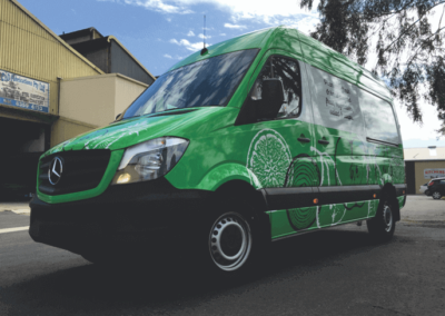A food delivery van featuring signs designed based on the companies logo and corporate colours