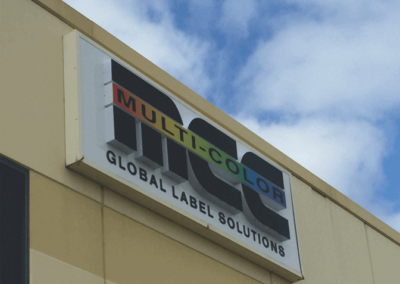 A backlit outdoor street sign with 3D lettering