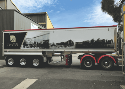 A long trailer on a semi features a generational large format printed sign
