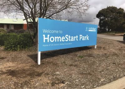 A large traditional outdoor sign featuring vinyl cut lettering erected in a park in Adelaide promoting Homestart park