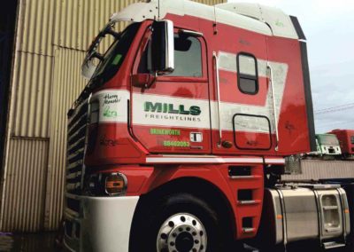 A semi-trailer showing both vinyl signage and traditional sign writing